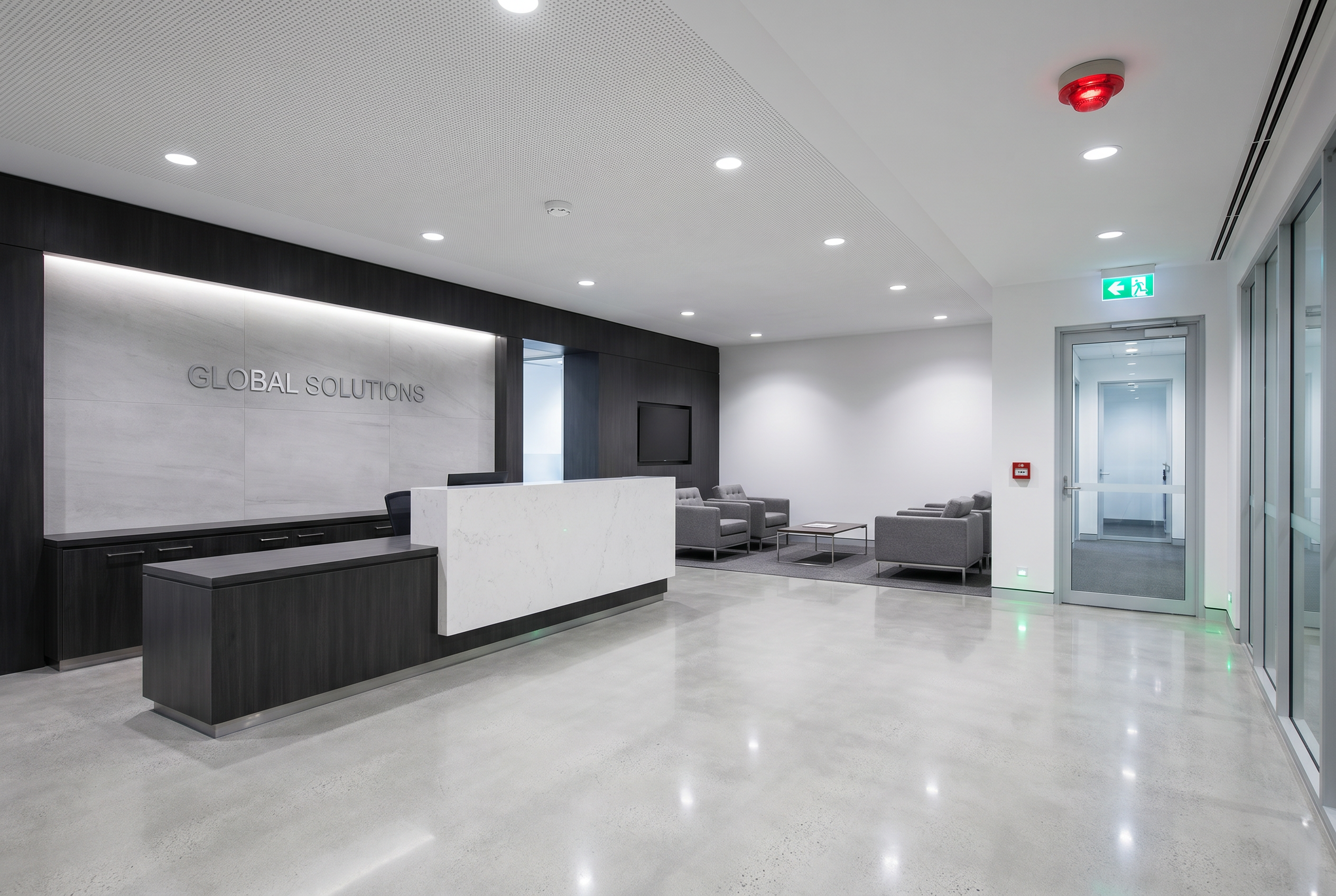 Modern office reception with illuminated ceiling and exit signage