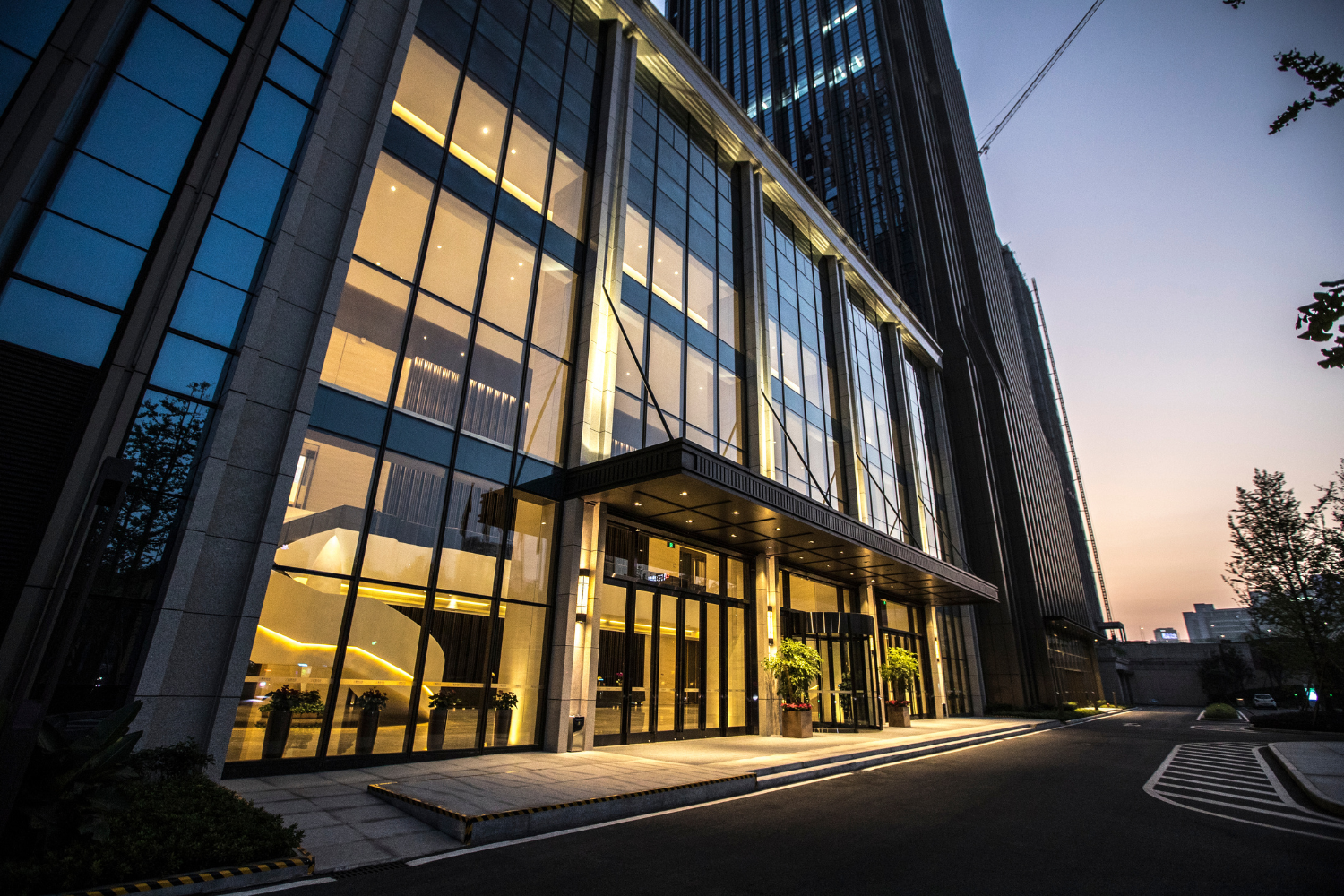 Glazed commercial building exterior lit at dusk
