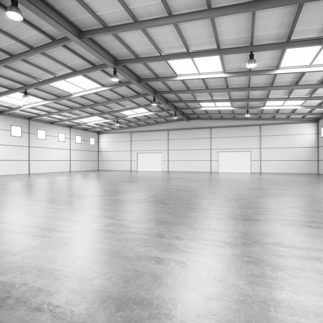 Empty industrial unit interior with roof lights and clean floor