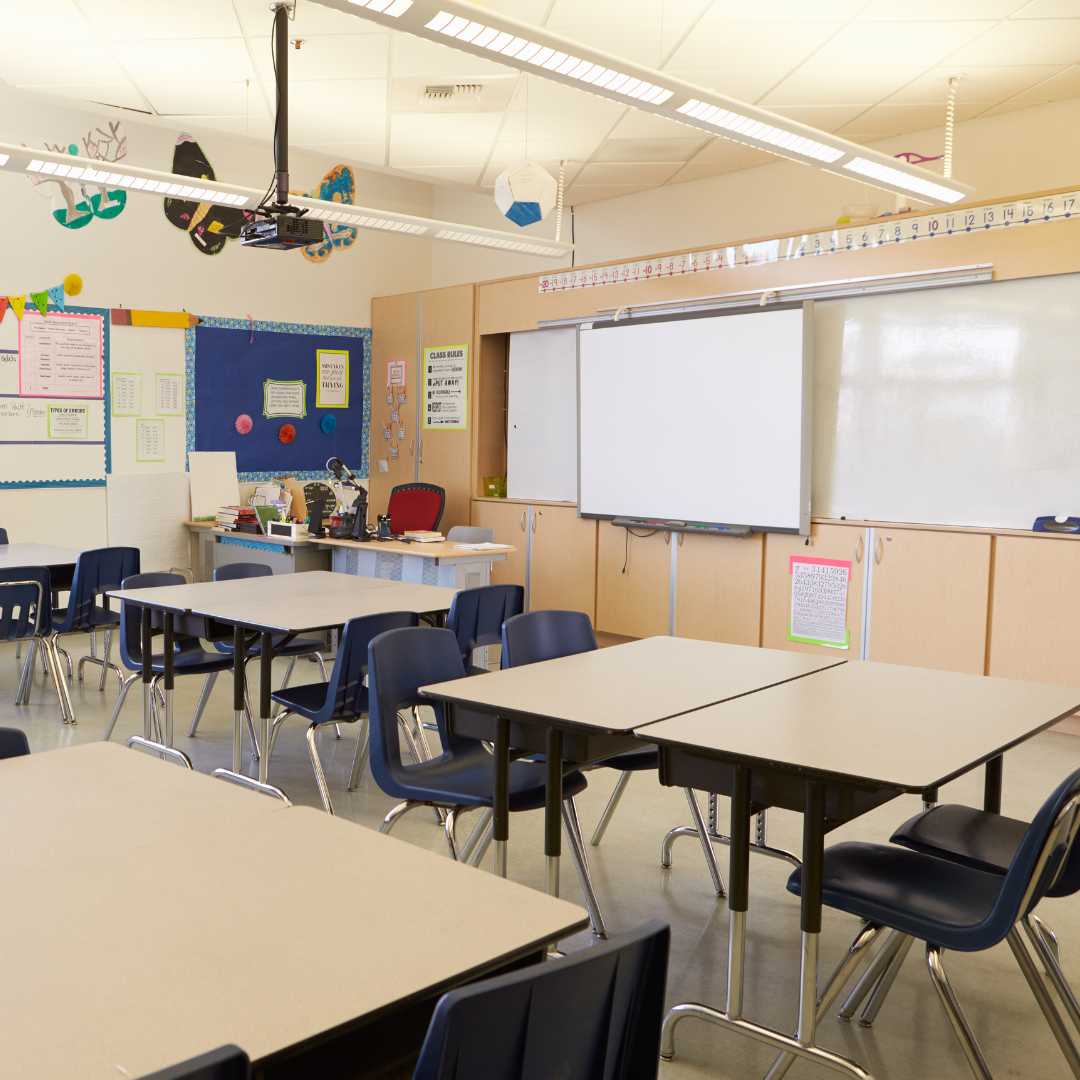 Primary school classroom with tables and whiteboard
