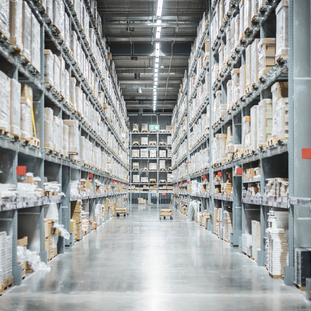 Warehouse racking aisle stacked with pallets beneath high-bay lighting